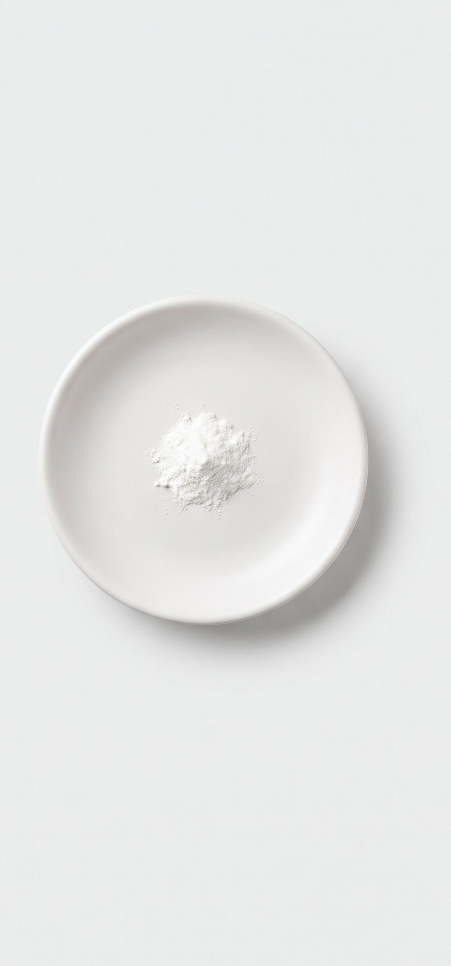 A pinch of white magnesium stearate powder on a dish.
